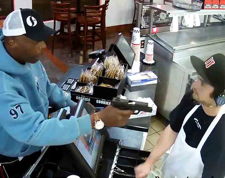 Cashier keeps calm while robber points gun at him