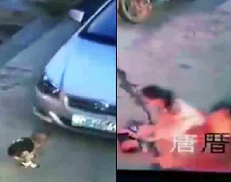 Woman with a baby stands motionless few feet away as a kid is run over by a car