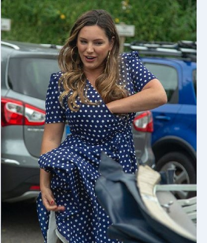 Kelly Brook rummages around her dress and exposes her bra as mic blunder