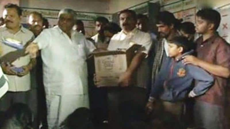 Minister H D Revanna throws biscuits at flood victims of Kodagu