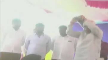 Karnataka Revenue Minister RV Deshpande throws sports kits from a stage to athletes Karwar