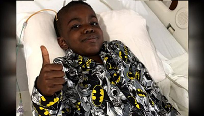 An 8 year old boy celebrates after beating stage 4 brain cancer