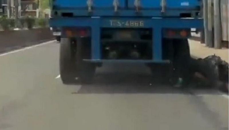 Biker comes under truck escapes miraculously thanks to helmet