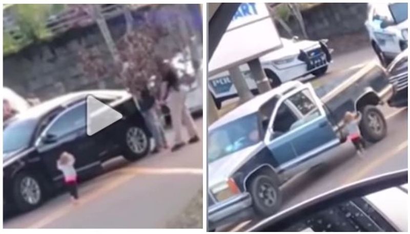 A toddler walks toward police with her hands up as her dad gets arrested