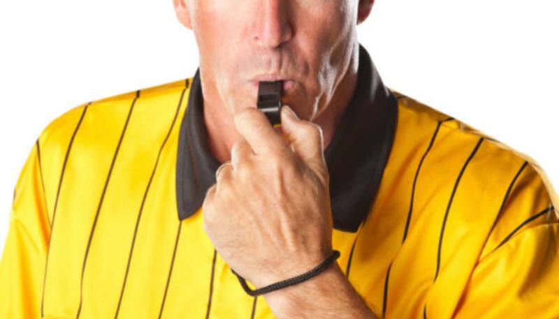 Referee blowing whistle