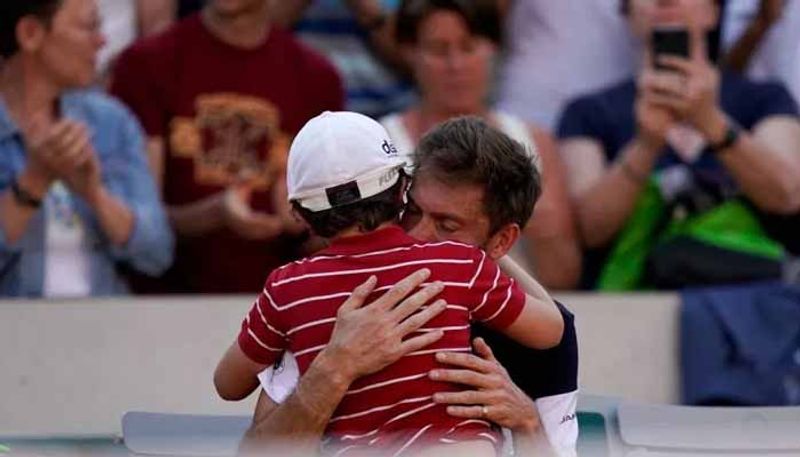 Nicolas Mahut comforted by his son