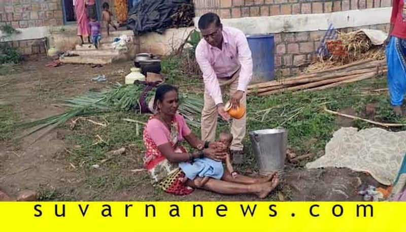 Officer help mother to make the two month old kid to take bath in gruel Center of Bagalkot