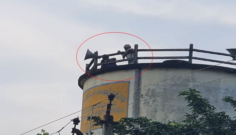 An elderly couple protest on water tank