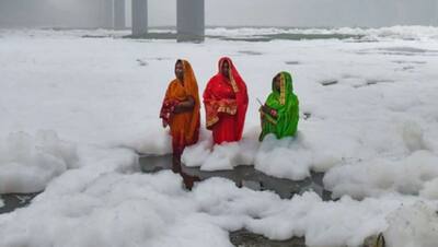 यह बर्फ नहीं बल्कि यमुना नदी में जमी गंदगी है, जिसमें उतरकर महिलाएं छठ पूज रही हैं