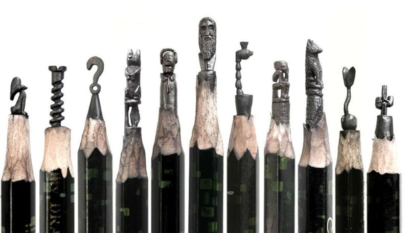 artist carving miniature sculptures on pencil tips