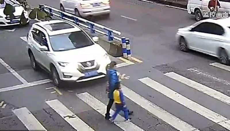 little boy kicks car and tells off driver after he knocks down mother on zebra crossing