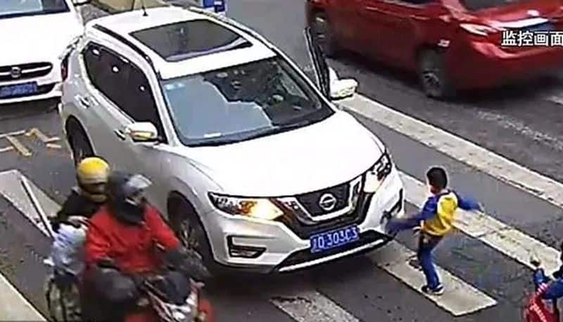 little boy kicks car and tells off driver after he knocks down mother on zebra crossing