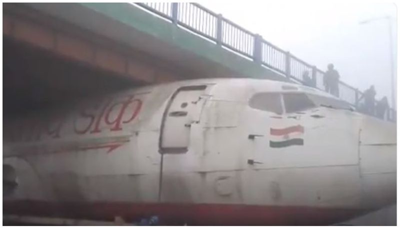 truck with abandoned aircraft stuck under bridge