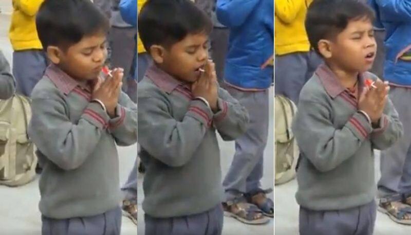 little boy sneakily enjoys candy during school morning assembly