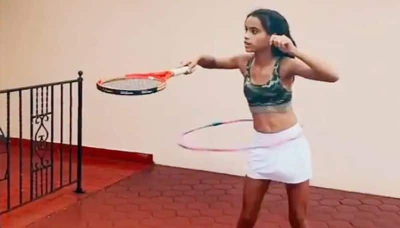 Young Girl Shows Off Tennis Skills While Doing Hula Hoops