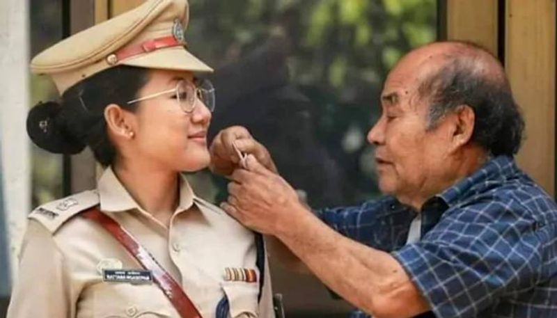 A proud father check the stars of cop daughter's uniform