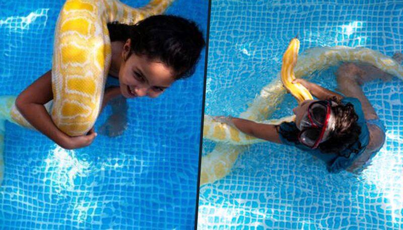 Watch 8-year-old girl swims with pet python - gps