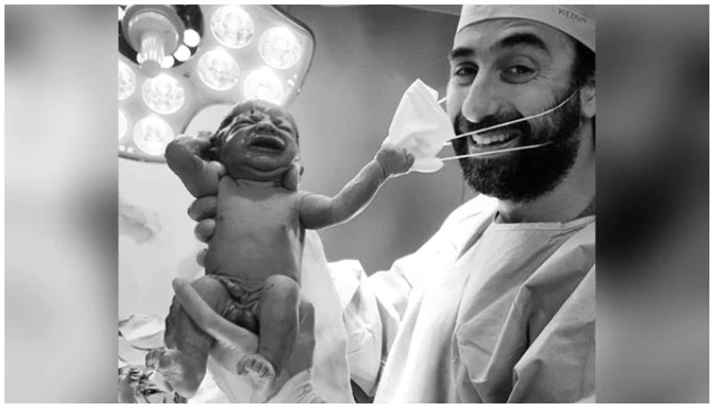 newborn baby trying to remove her doctors surgical mask has become a viral