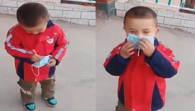 small boy video goes viral who is wearing mask and eating lollipop