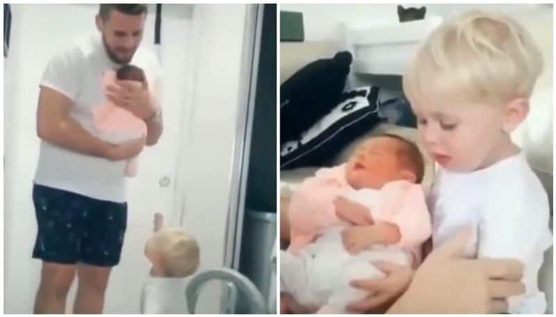 Toddler holds baby sister in his arms in cute viral video Internet hearts it