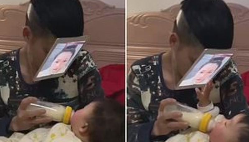 father ties on a photo of his wifes face to feed baby