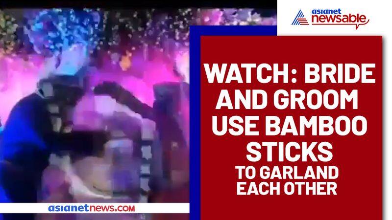 Unique Marriage: Couple exchange Garlands using bamboo sticks to Maintain Social Distancing; Watch Video - gps