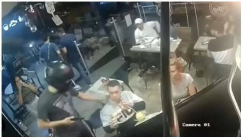 A young man eating quietly in the midst of a robbery with a gun viral images