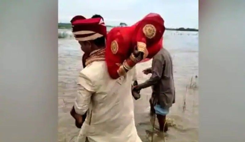 video of groom carries  bride  to cross  river