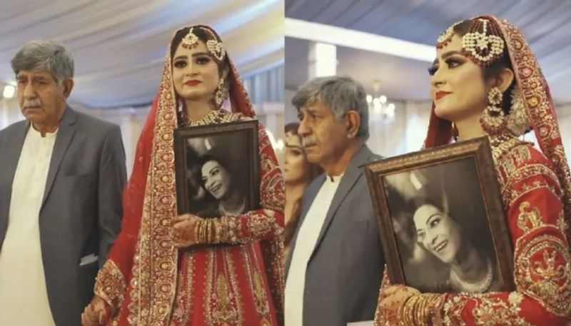 Bride enters wedding venue holding a photo of her mother