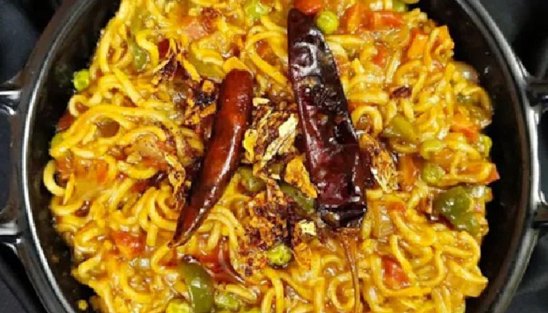 street vendor makes noodles with cold drink