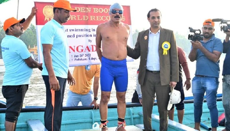 65 year old Gangadhar swims for 5 hrs in sea with limbs chained in Udupi and Create Golden Book of World Record kvn