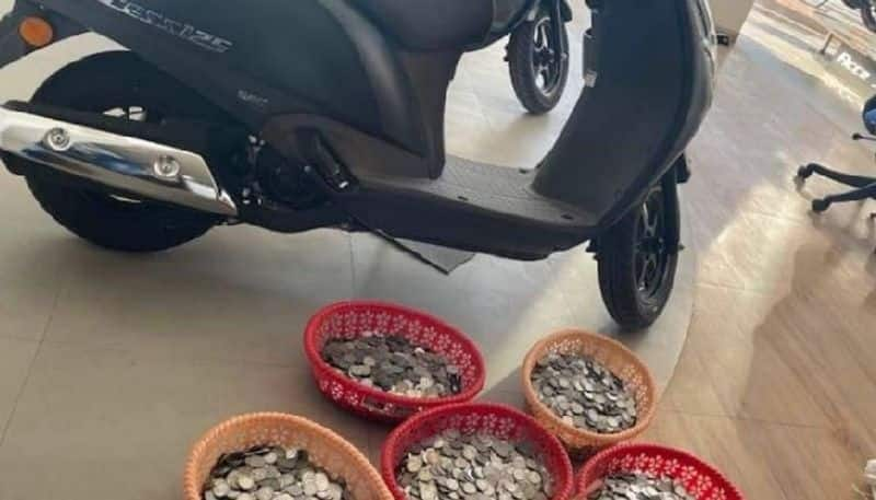 vegetable vendor reaches two wheeler showroom with a sack of coins