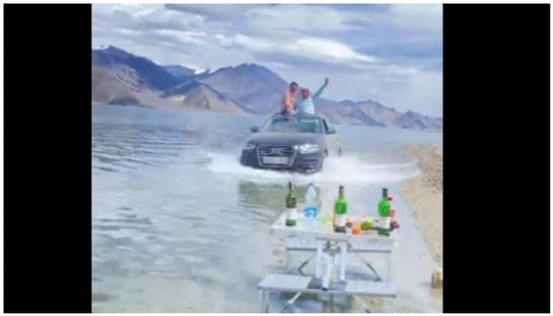 Tourists Driving SUV Through Ladakh's Pangong Lake