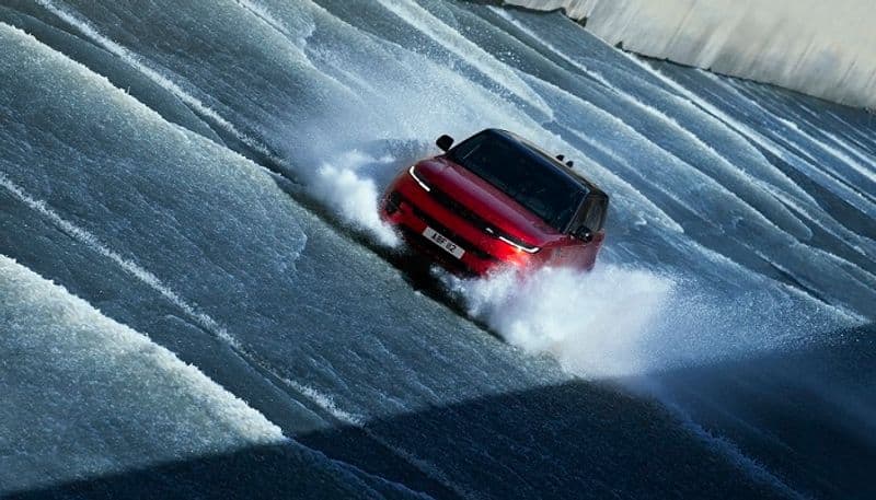 Range Rover Sport complet challenging ascent dam spillway against a torrent of water flowing ckm