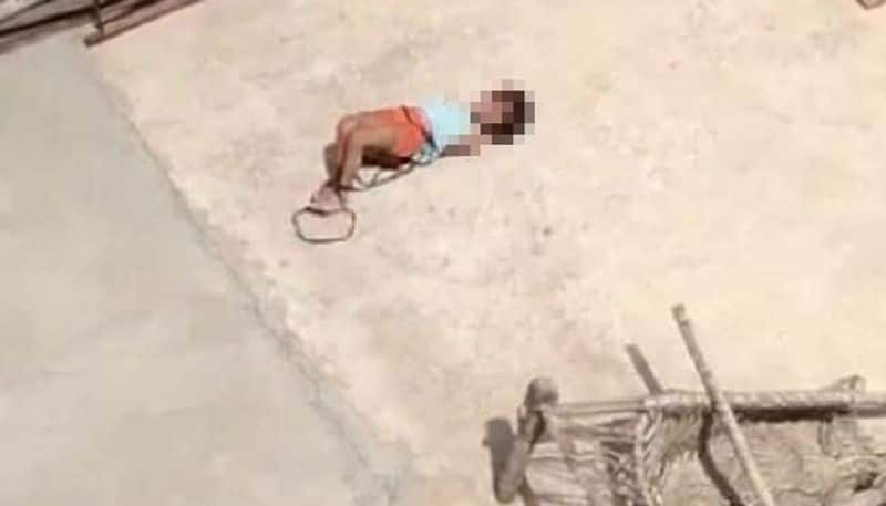 video in which child seen as hands and legs tied writhes on hot roof 