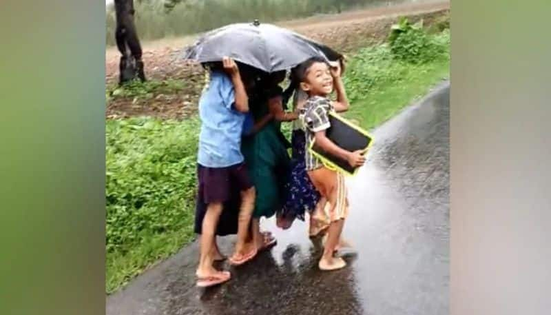 nostalgic rain video in which kids going in rain with one umbrella 