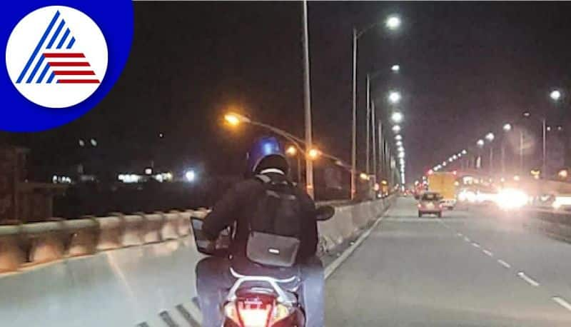 pillion rider working with laptop at one of busy flyover in Bangalore akb