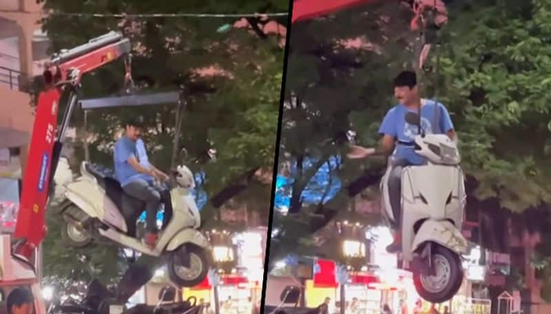 Man casually sits on hanging scooter while traffic police towed it; dramatic video goes viral - gps