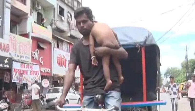 viral video in which rikshaw puller holds baby while he drive 