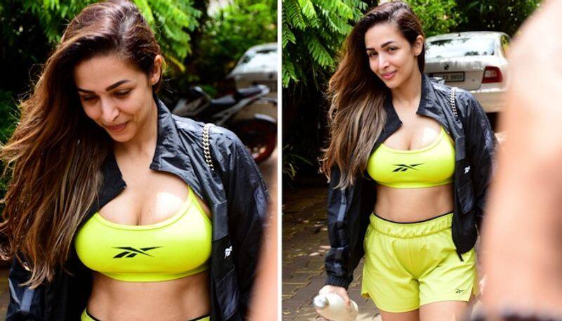 Sexy pictures bollywood diva Malaika Arora flaunts her assets in florescent green cleavage revealing sports bra and shorts snt