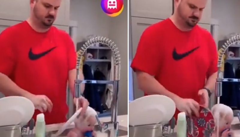 man washing dishes and toddler in the same kitchen sink