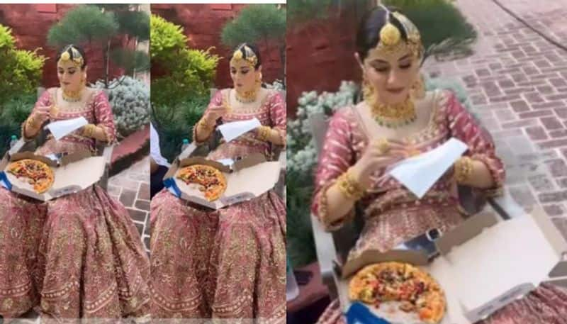 Hungry bride relishes a pizza before wedding ceremonies