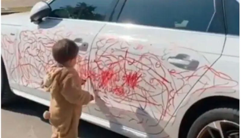 Boy Scribbles On A Car With Lipstick