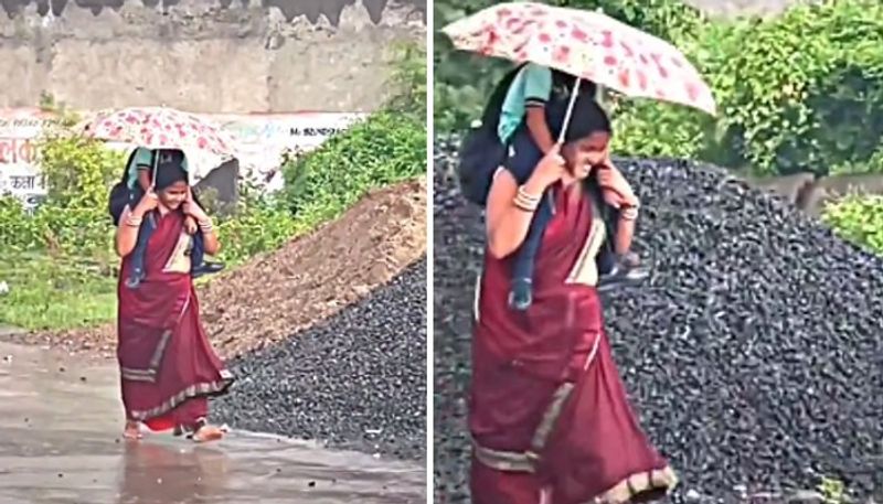 mother carrying her daughter on shoulders while walking in rain 