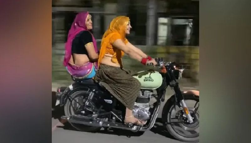 woman riding royal enfield in traditional dress 