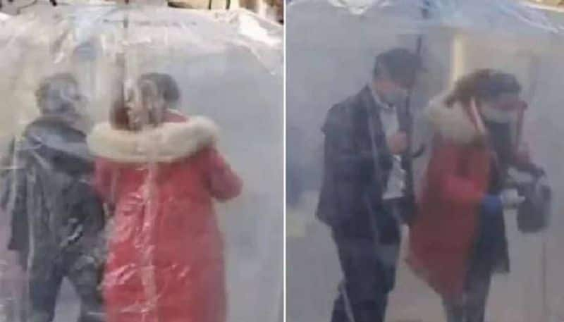 Chinese couple use covid 19 proof umbrella 