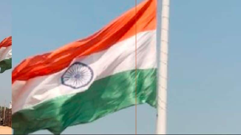 A torn national flag flying on a tall flagpole at hospet rav