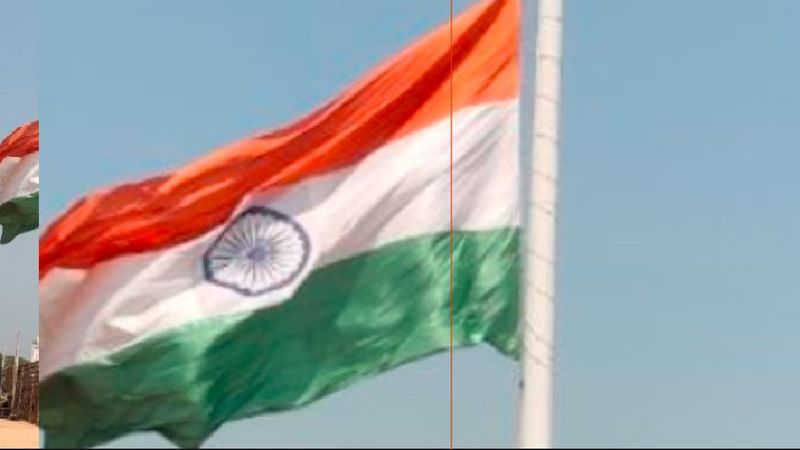 A torn national flag flying on a tall flagpole at hospet rav