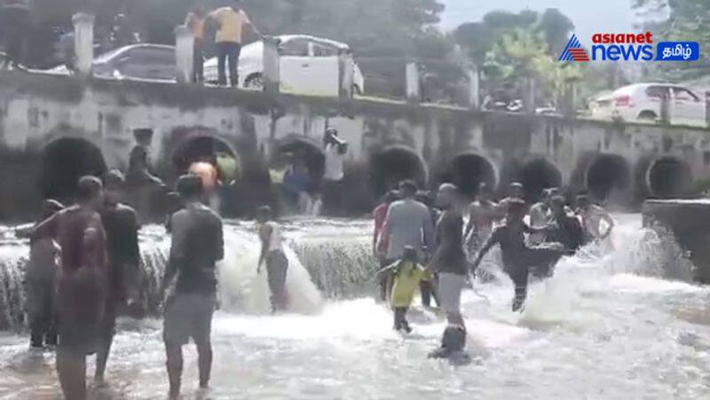 Tourists enjoying bathing in kovai kutralam falls