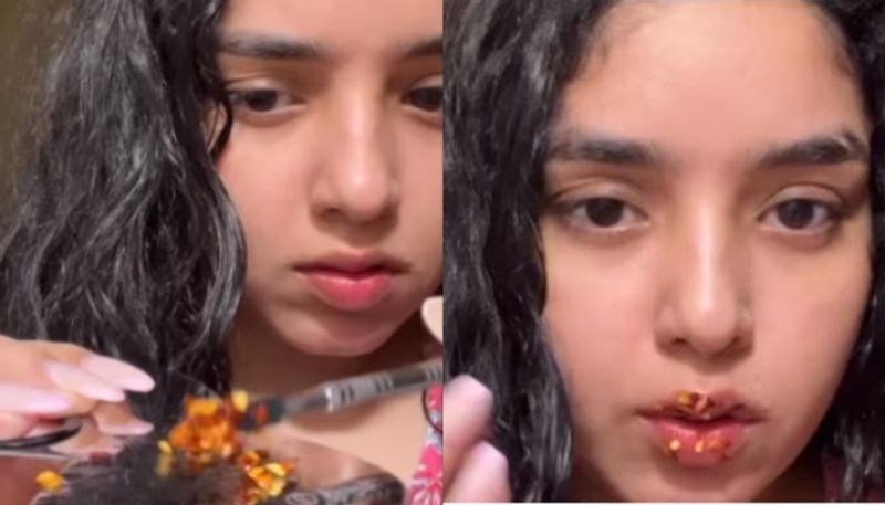 Woman applies gloss mixed with chilli flakes on lips azn